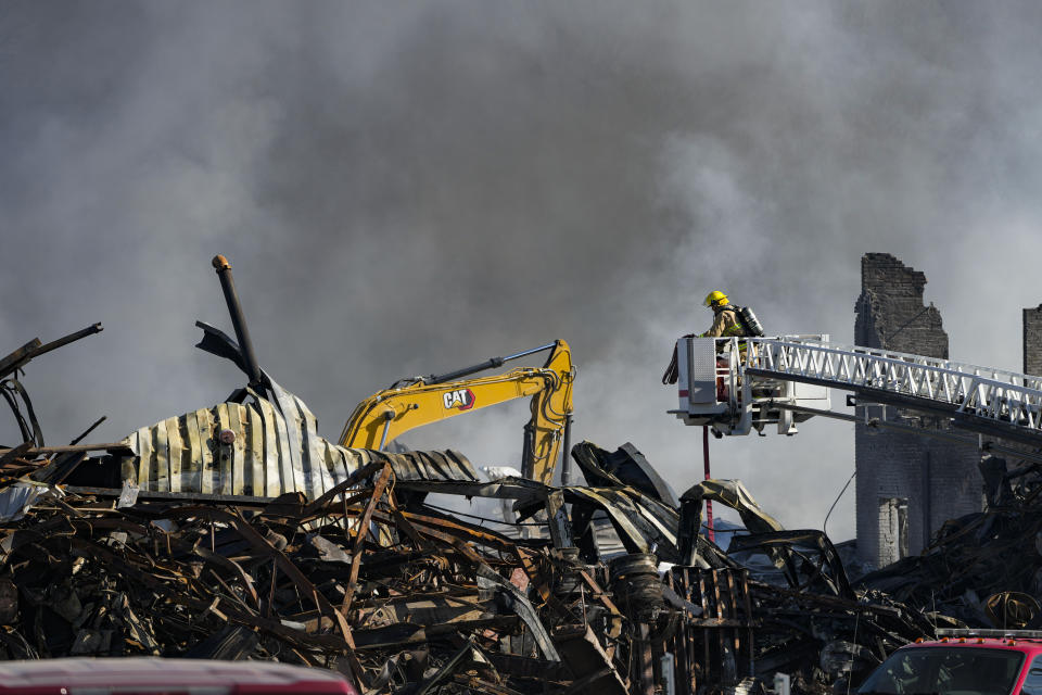 Firefighters pour water on an industrial fire in Richmond, Ind., Thursday, April 13, 2023. Multiple fires that began burning Tuesday afternoon were still burning within about 14 acres of various types of plastics stored inside and outside buildings at the former factory site. (AP Photo/Michael Conroy)