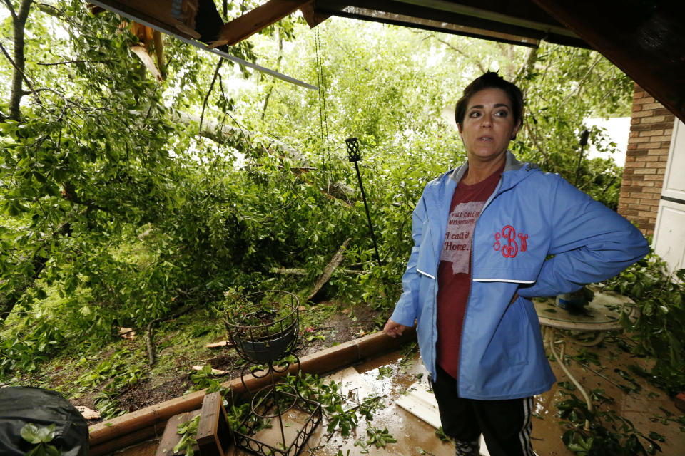 Sonya Banes reacts to a large oak tree that crashed through the patio of her mother's house in Learned, Miss., Thursday, April 18, 2019. Several homes were damaged by fallen trees in the community. Strong storms again roared across the South on Thursday, topping trees and leaving more than 100,000 people without power across Mississippi, Louisiana and Texas. (AP Photo/Rogelio V. Solis)