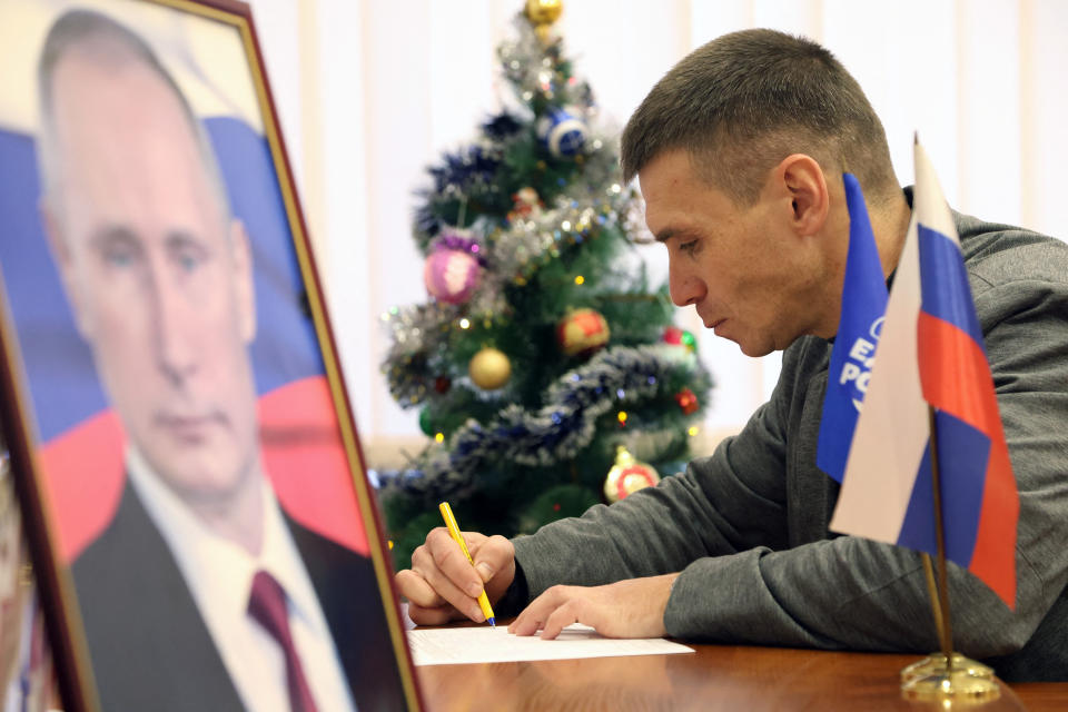 A man fills in a form to put his signature in support of Vladimir Putin in occupied Crimea. (AP)