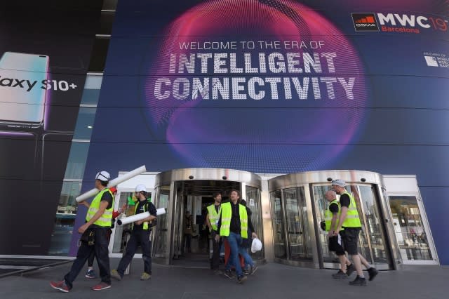 A group of MWC workers walk outside the 2019 Mobile World Congress venue few days before its opening in Barcelona on February 23 February, 2019. (Photo by LLUIS GENE / AFP)        (Photo credit should read LLUIS GENE/AFP/Getty Images)