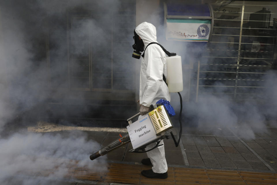 A firefighter disinfects a sidewalk the against new coronavirus, in western Tehran, Iran, Friday, March 13, 2020. The new coronavirus outbreak has reached Iran's top officials, with its senior vice president, Cabinet ministers, members of parliament, Revolutionary Guard members and Health Ministry officials among those infected. The vast majority of people recover from the new coronavirus. According to the World Health Organization, most people recover in about two to six weeks, depending on the severity of the illness. (AP Photo/Vahid Salemi)