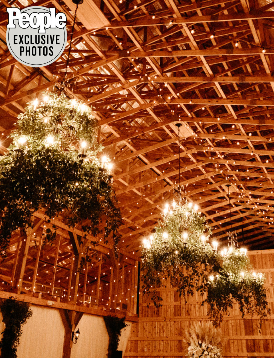 <p>The wood-beamed venue was decorated in neutral colors with greenery and lots of candles.</p>