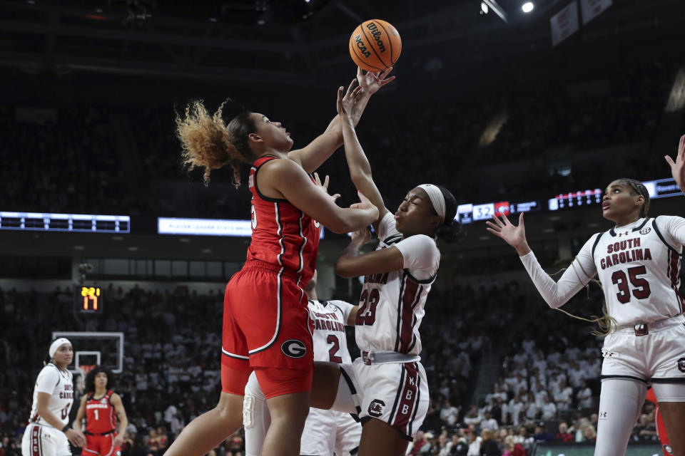 Georgia forward Javyn Nicholson, left, shoots over South Carolina guard Bree Hall (23) during the first half of an NCAA college basketball game, Sunday, Feb. 18, 2024, in Columbia, S.C. (AP Photo/Artie Walker Jr.)