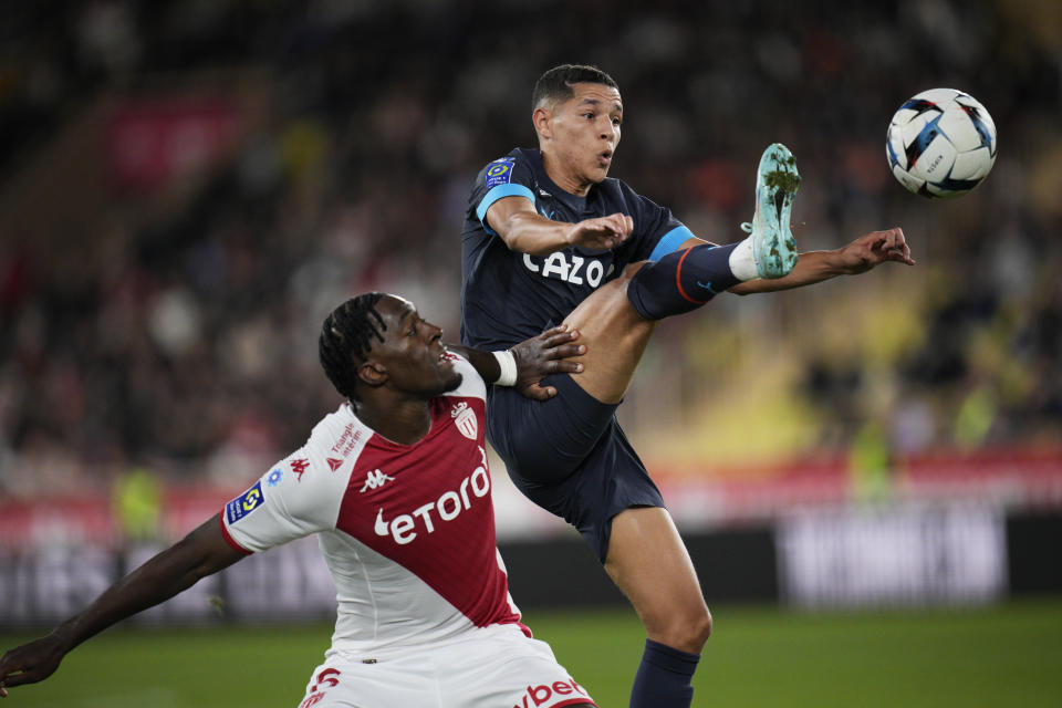 Marseille's Amine Harit, right, and Monaco's Axel Disasi challenge for the ball during the French League One soccer match between Monaco and Marseille at the Stade Louis II in Monaco, Sunday, Nov. 13, 2022. (AP Photo/Daniel Cole)