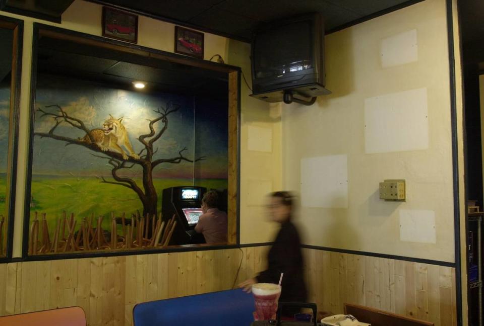 Assistant Manager Sandy Rose walks past a nicotine-stained wall where framed pictures once hung at the Tolly-Ho Restaurant near the UK campus in Lexington, Ky., on 12/24/03. The 24-hour restaurant, known for it’s burgers, crowds and clouds of smoke, will be smoke-free after they reopen after their 11-days of vacation during which employees will be cleaning, painting, and refurbishing to help clean out the years of nicotine stains. Assistant manager Sandy Rose said that the walls were painted 6 months ago.