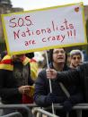 A demonstrator against independence for Catalonia holds a sign in front of Catalonia's regional parliament as lawmakers votes in Barcelona January 16, 2014. Local lawmakers in the north-eastern Spanish region of Catalonia voted to seek a referendum on breaking away from Spain on Thursday, setting themselves up for a battle with an implacably opposed central government in Madrid. The Catalan Parliament in Barcelona voted 87 to 43, with 3 abstentions, to send a petition to the national parliament seeking the power to call a popular vote on the region's future. REUTERS/Albert Gea (SPAIN - Tags: POLITICS CIVIL UNREST)