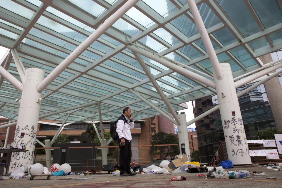 Professor Alex Wai, Vice President of the Polytechnic University, takes in the vandalized campus as he leads a team of school officials and first aid providers to look for holed up protesters on a roof top of the campus in Hong Kong, Tuesday, Nov. 26, 2019. Hong Kong's embattled leader Carrie Lam refused to offer any concessions to anti-government protesters despite a local election trouncing, saying Tuesday that she will instead accelerate dialogue and identify ways to address societal grievances. (AP Photo/Ng Han Guan)