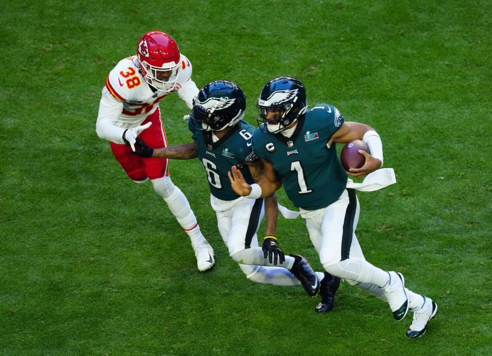 Philadelphia Eagles quarterback Jalen Hurts (1) runs the ball as wide receiver DeVonta Smith (6) blocks Kansas City Chiefs cornerback L'Jarius Sneed (38) in the first quarter in Super Bowl LVII at State Farm Stadium in Glendale on Feb. 12, 2023.