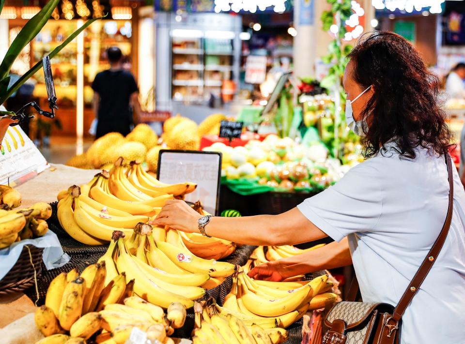 A woman chooses bananas at a supermarket in Nanning, south China's Guangxi Zhuang Autonomous Region, Sept. 7, 2023. / Credit: Hu Xingyu/Xinhua/Getty