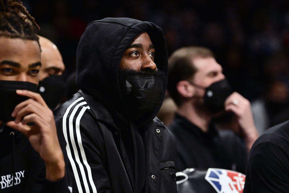 James Harden looks on from the bench.