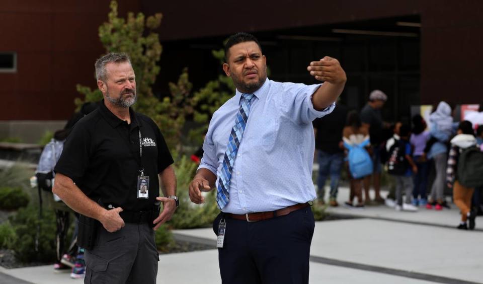 School Safety Officer Scott Child, left, and Amistad Elementary Principal Julio Blanco discuss the flow of buses and vehicles through the Kennewick school’s parking lot on the first morning of classes this week.