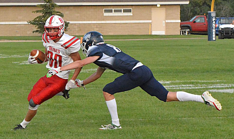 Britton-Hecla's Daniel Person turns the corner against Great Plains Lutheran's Alex Heil during their season-opening high school football game on Friday, Aug. 18, 2023 at Watertown Stadium.