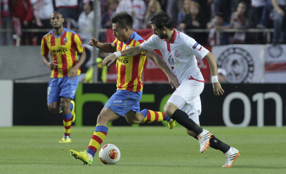 Sevilla's Nico Pareja, right, and Valencia's Javi Fuego, left, vie for the ball during their Europa League semifinal first leg soccer match at the Ramon Sanchez Pizjuan stadium, in Seville, Spain on Thursday, April 24, 2014. (AP Photo/Miguel Angel Morenatti)