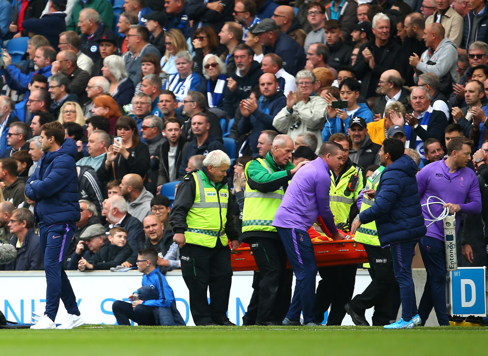 Hugo Lloris is taken off on a stretcher, passing Mauricio Pochettino. (Photo by Charlie Crowhurst/Getty Images)