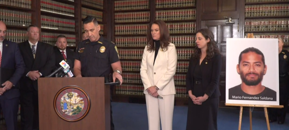 Jacksonville Beach Police Chief Gene Paul Smith addresses the media alongside State Attorney Melissa Nelson about the March 16 arrest of Mario Fernandez Saldana in the poster at right. He is the second person charged in the Feb. 16, 2022, ambush shooting death of Jared Bridegan.