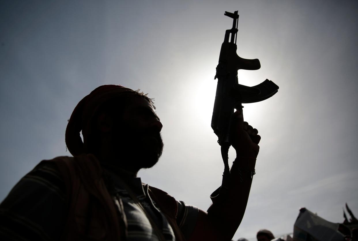 A silhouette of a Houthi supporter holds his weapon during a rally last month (AP)