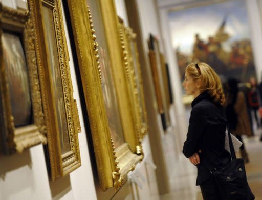 A woman looks at a painting during a press preview for the Metropolitan Museum of Art's New American Wing Galleries for Paintings, Sculpture and Decorative Arts in New York. The new galleries are part of a $100 million renovation of the museum