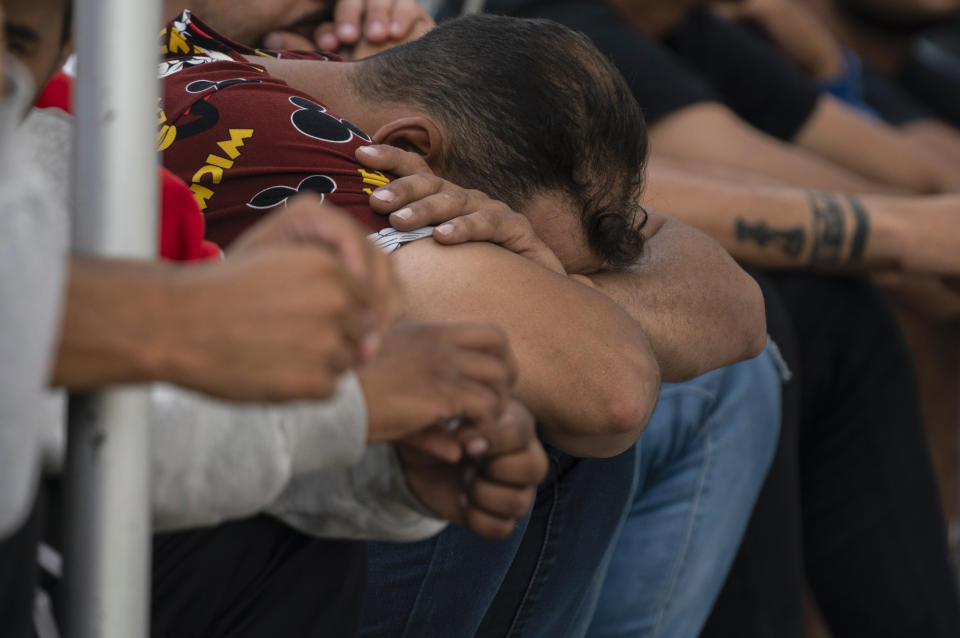 Migrants wait at the Gateway International Port of Entry under U.S. Customs and Border Protection custody in Brownsville, Texas, Friday, May 5, 2023, before being sent back to Mexico. (AP Photo/Veronica G. Cardenas)