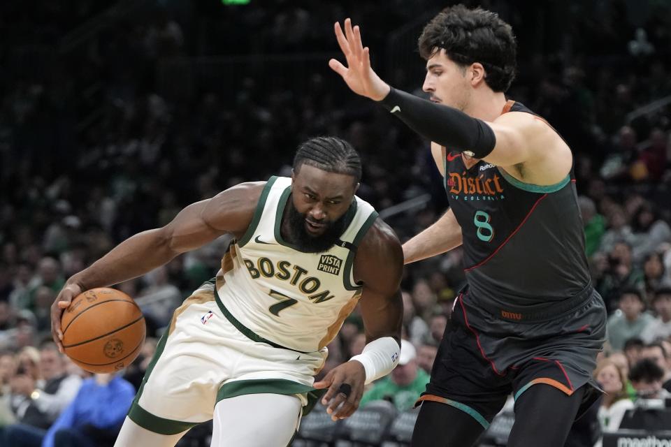 Boston Celtics' Jaylen Brown (7) drives past Washington Wizards' Deni Avdija (8) during the first half of an NBA basketball game Friday, Feb. 9, 2024, in Boston. (AP Photo/Michael Dwyer)