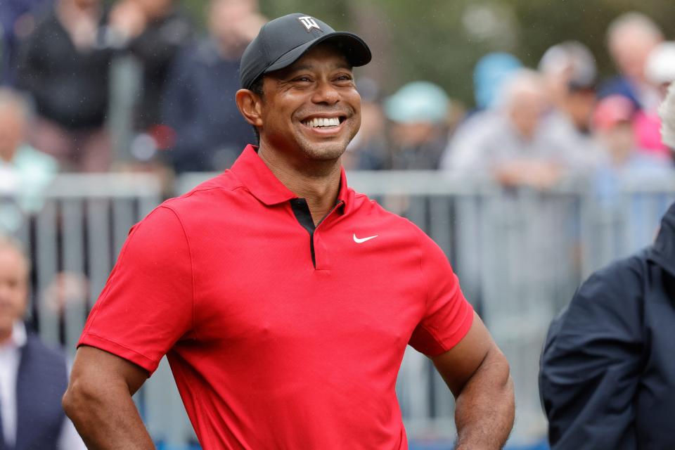 Tiger Woods smiles before he plays his shot from the first tee during the PNC Championship at The Ritz-Carlton Golf Club.