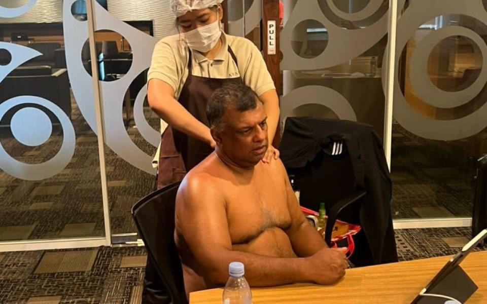 AirAsia boss Tony Fernandes has a massage during a meeting