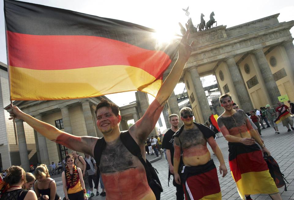 FILE -German soccer fans celebrate after the Group A, World Cup soccer match Germany v Ecuador in front of the Brandenburg Gate in Berlin on Tuesday, June 20, 2006. Germany gets the 2024 European Championship underway against Scotland in Munich on Friday. However, away from the stadiums and public-viewing areas, few German flags are flying. Germany's dark history, rising far-right cast shadow on national pride before it hosts Euro 2024. (AP Photo/Markus Schreiber, File)