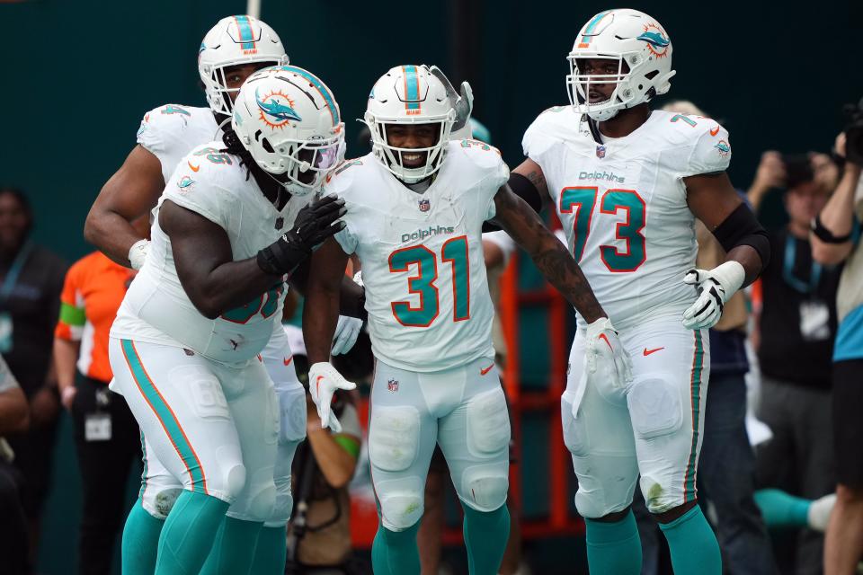 Dec 17, 2023; Miami Gardens, Florida, USA; Miami Dolphins running back Raheem Mostert (31) celebrates with teammates after scoring a touchdown against the New York Jets during the first half at Hard Rock Stadium. Mandatory Credit: Jasen Vinlove-USA TODAY Sports