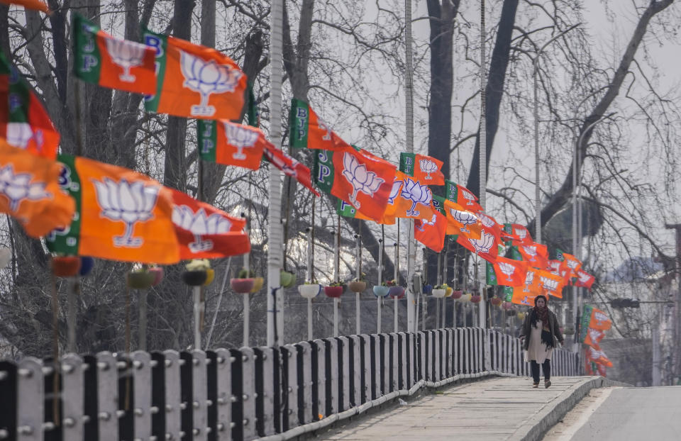 A woman walk past India's ruling Bharatiya Janata Party (BJP) party flags displayed ahead of the Indian Prime Minister Narendra Modi's visit to Srinagar, Indian controlled Kashmir, Wednesday, March 6, 2024. Modi is scheduled to address a public rally in Srinagar on Thursday. (AP Photo/Mukhtar Khan)