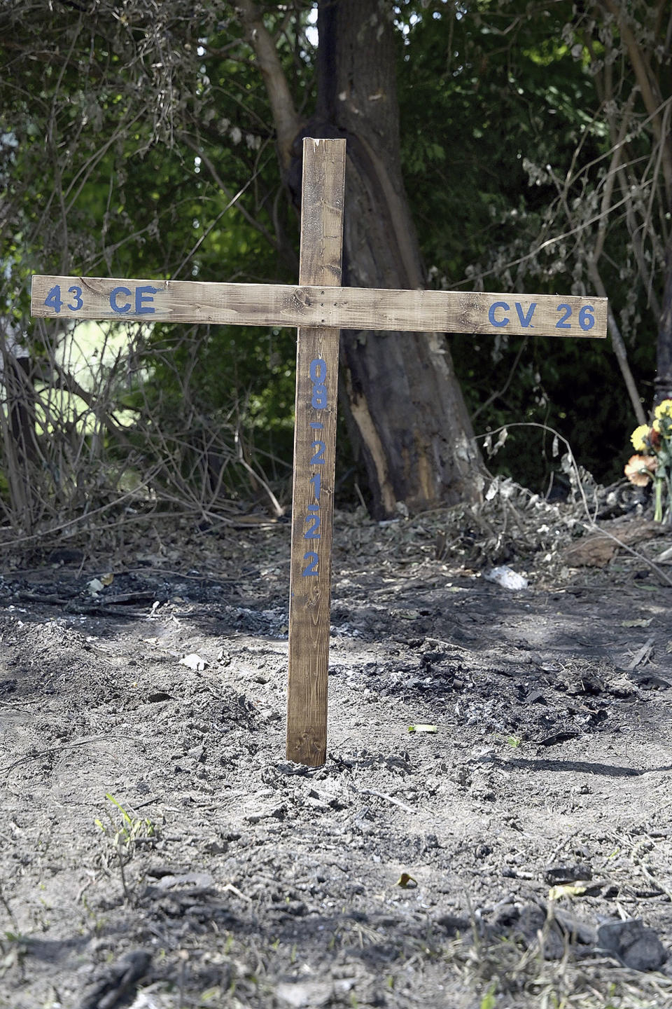 A homemade cross with the initials and jersey numbers of Indiana State NCAA college football players Christian Eubanks and Caleb VanHooser sits at the site of the tragic car crash that left three students dead and two hospitalized with serious injuries, four of them football players, in Riley, Ind., Tuesday, Aug. 23, 2022, (Joseph C. Garza/The Tribune-Star via AP)