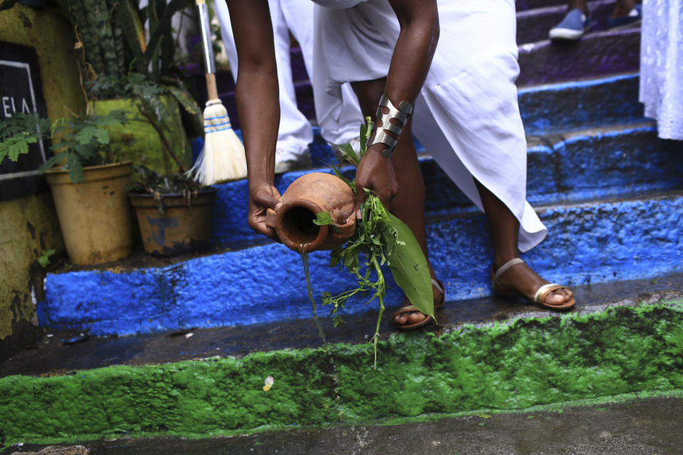 A members= of the Mocidade Unida do Santa Marta samba school performs a washing ritual for good luck called "Lavagem" at a ceremony marking Black Consciousness Day in the Santa Marta favela of Rio de Janeiro, Brazil, Friday, Nov. 20, 2020. Brazilians celebrate the holiday with Afro-Brazilian dance, music and religious ceremonies, reflecting the deep cultural and social ties of the Black community to the country’s history and honor legendary anti-slave leader Zumbi dos Palmares on the day of his death. (AP Photo/Bruna Prado)