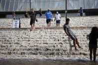 Dominic Aguilera slides down a hand rail into a parking structure outside Pauley Pavilion sporting arena as water flows down stairs from a broken thirty inch water main that was gushing water onto Sunset Boulevard near the UCLA campus in the Westwood section of Los Angeles July 29, 2014. The geyser from the 100-year old water main flooded parts of the campus and stranded motorists on surrounding streets. REUTERS/Danny Moloshok