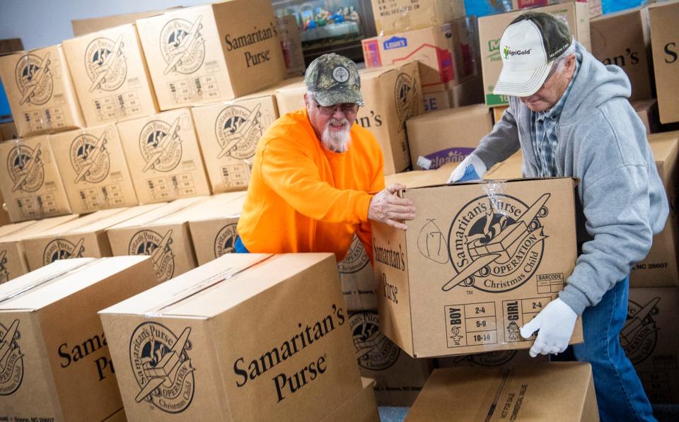 David Hollars, right, and Terry Mullins begin to load over 1,400 gift boxes for Operation Christmas Child at Burgoon Baptist Church on Wednesday, Nov. 16, 2022.