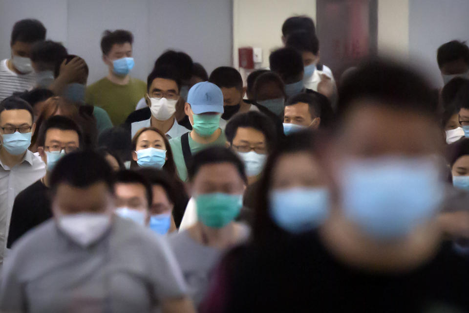 Commuters wear face masks to protect against the new coronavirus as they walk through a subway station in Beijing, Tuesday, June 23, 2020. China reported about 20 new cases of coronavirus on Tuesday, including more than a dozen in Beijing, a day after a city government spokesperson said containment measures had slowed the momentum of an outbreak in the capital. (AP Photo/Mark Schiefelbein)