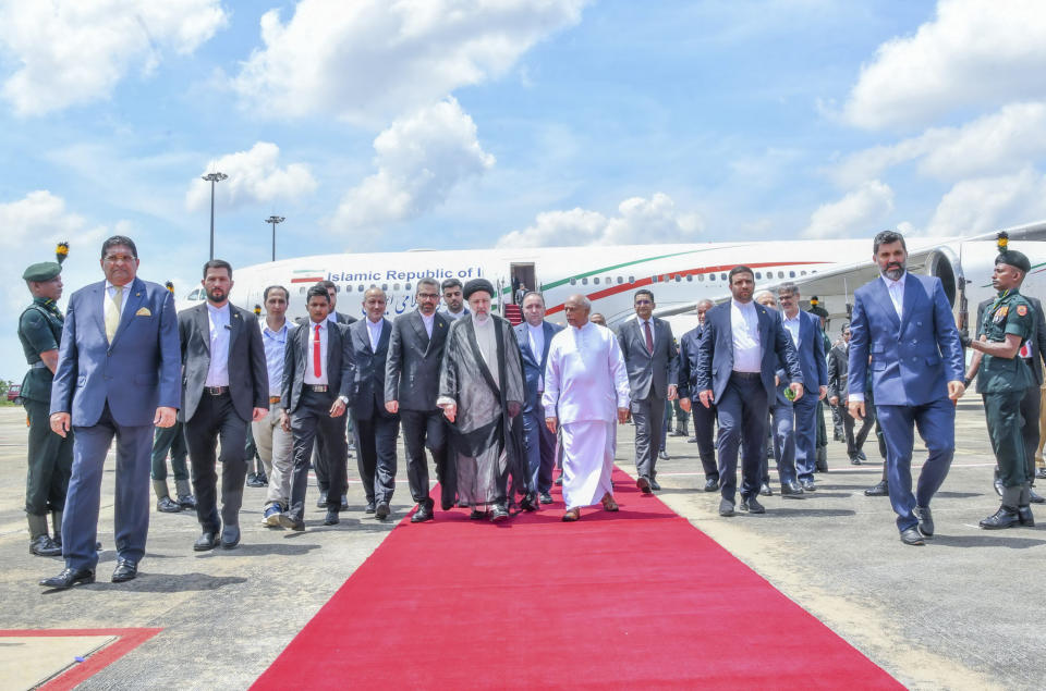 Iranian President Ebrahim Raisi, center left is received by Sri Lankan Prime Minister Dinesh Gunawardena, in white as he arrives at the Mattala International airport in Mattala, Sri Lanka, Wednesday, April 24, 2024. (Sri Lanka President's Office via AP)