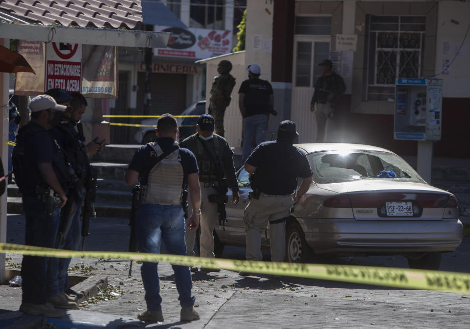 Police work the area of a massive shootout in Parangaricutiro, Mexico,Thursday, March 10, 2022. Authorities in the avocado-growing zone of western Mexico said five suspected drug cartel gunmen have been killed in a massive firefight between gangs. ( AP Photo/Armando Solis)