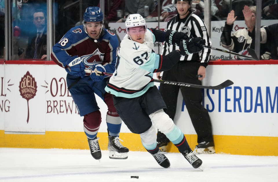 Seattle Kraken center Morgan Geekie (67) pursues the puck with Colorado Avalanche center Alex Newhook (18) in the first period of an NHL hockey game Sunday, March 5, 2023, in Denver. (AP Photo/David Zalubowski)
