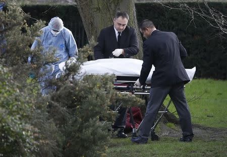 A forensic police officer and undertakers strap a body to a gurney near the grounds of Kensington Palace in London, Britain February 9 2016. REUTERS/Neil Hall