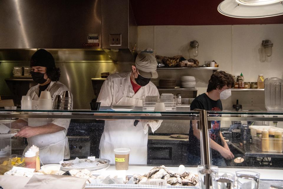 Employees of the Lobster Trap prepare food for customers during dinner January 13, 2022.