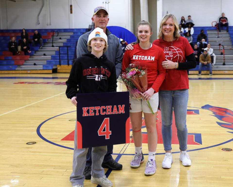 Ketcham's Camryn Greene, center, is flanked by her parents, Dennis and Laurie, and her brother Braeden during the girls basketball team's senior night ceremony on Feb. 7, 2023.