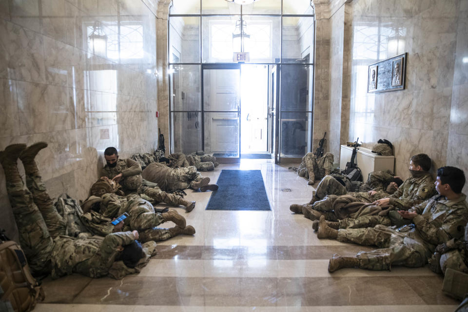 Members of the National Guard rest in a hallway of the Capitol