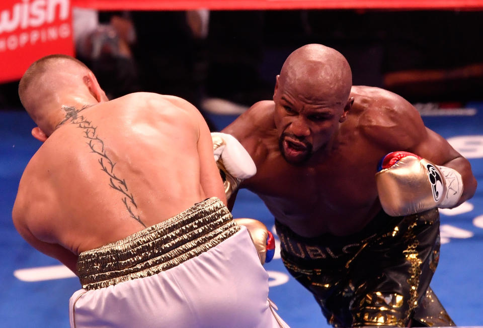 LAS VEGAS, NV - AUGUST 26:  (R-L) Floyd Mayweather Jr. throws a punch at Conor McGregor during their super welterweight boxing match on August 26, 2017 at T-Mobile Arena in Las Vegas, Nevada.  (Photo by Jeff Bottari/Zuffa LLC/Zuffa LLC via Getty Images )