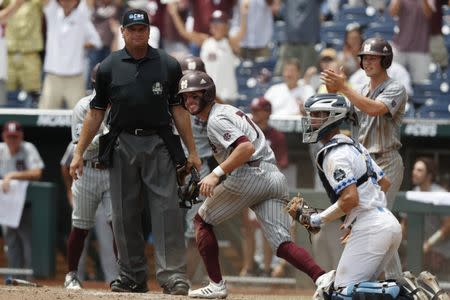 Jun 19, 2018; Omaha, NE, USA; Mississippi State Bulldogs shortstop Luke Alexander (7) scores against North Carolina Tar Heels catcher Brandan Martorano (4) in the eighth inning in the College World Series at TD Ameritrade Park. Mandatory Credit: Bruce Thorson-USA TODAY Sports