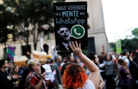 A woman holds a sign with an image of presidential candidate Jair Bolsonaro that reads "He lies in WhatsApp," during a protest against Bolsonaro in Sao Paulo, Brazil, October 20, 2018. REUTERS/Nacho Doce