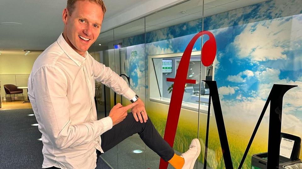 Dan Walker pointing to his bold orange socks