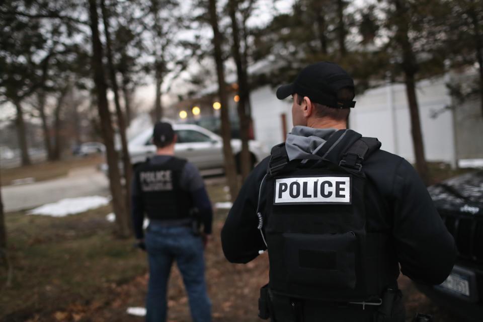 Customs and Border Protection officers watch a house in Brentwood, New York.