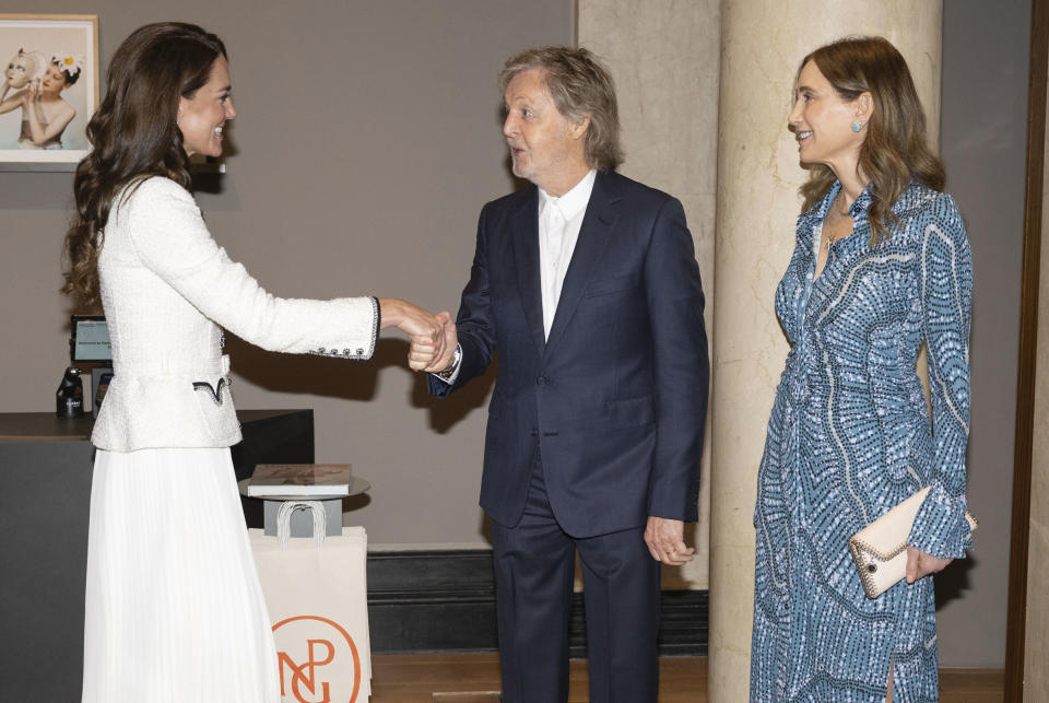 Catalina, la princesa de Gales, estrecha la mano de Sir Paul McCartney, al centro, mientras los observa su esposa Nancy Shevell, derecha, durante una visita para reinaugurar la Galería Nacional de Retratos luego de una renovación de tres años, el martes 20 de junio de 2023, en Londres. (Paul Grover, fotografía compartida vía AP)