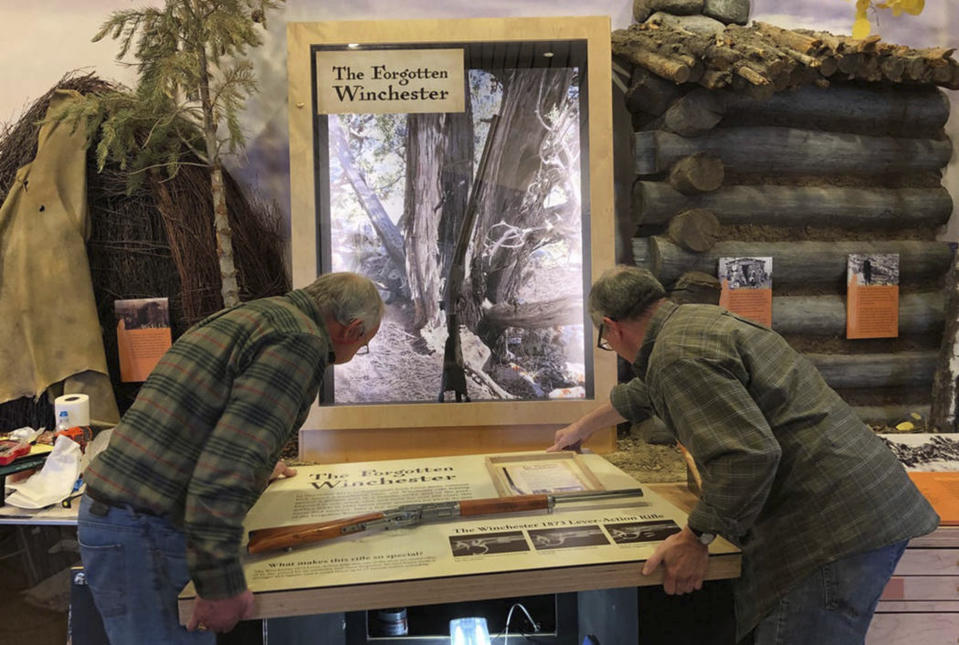 In this April 2019 photo workers for the design company DiVittorio and Associations help install the new exhibit at the visitor center at Great Basin National Park in Baker, Nev. for the "Forgotten Winchester," an 1882 rifle that was discovered leaning against a tree in 2014. (National Park Service via AP)