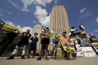 Protesters hold signs outside city hall Thursday, Oct. 8, 2020, in Kansas City, Mo., demanding the resignation of an officer who knelt on the back of nine-months-pregnant Black woman, Deja Stallings, while arresting her the previous week, and Police Chief Rick Smith. (AP Photo/Charlie Riedel)