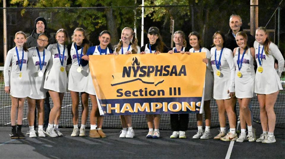 Oneida Express tennis players pose with their Section III championship banner after beating Jamesville-DeWitt Thursday at the John Mott Parkway Tennis Center in Utica.