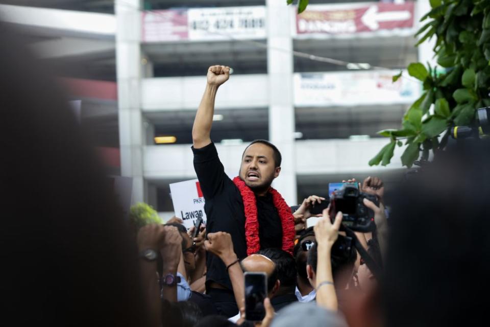 Farhash Wafa Salvador Rizal Mubarak gestures to the crowd as he leaves the Dang Wangi police station in Kuala Lumpur July 23, 2019. ― Picture by Ahmad Zamzahuri